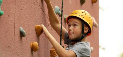 boy climbing wall at camp