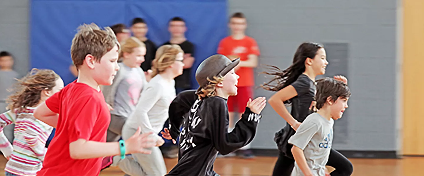 large group of youth running in gym