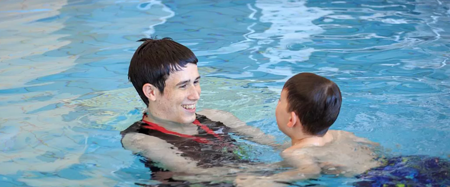 swim instructor with child in pool
