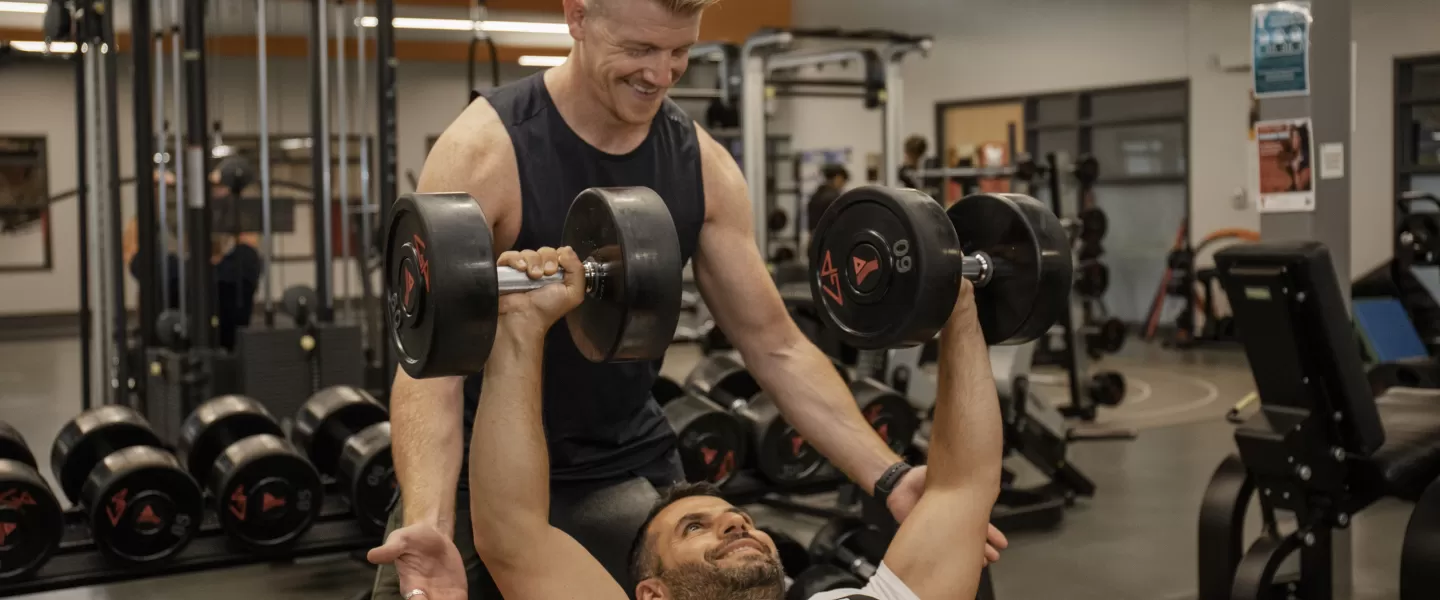 Personal trainer spotting for someone working out