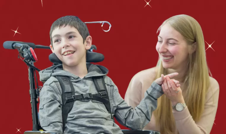 A boy and young woman smile holding hands