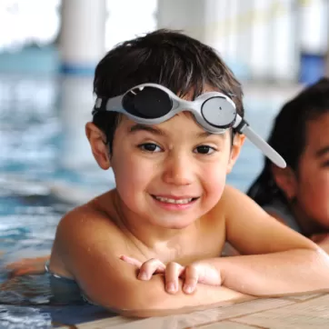 kids floating on the edge of a pool