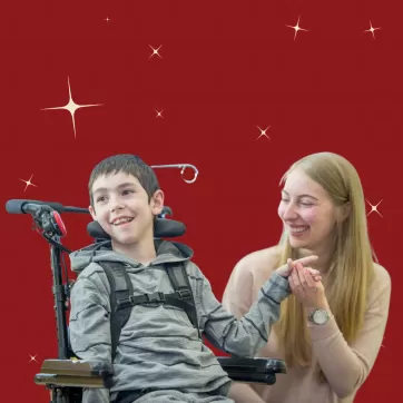 A boy and young woman smile holding hands