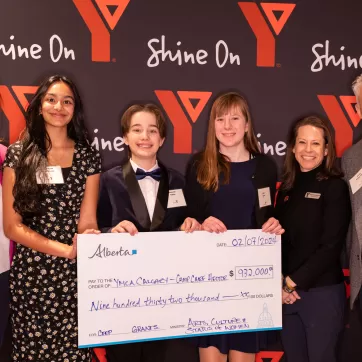 Minister Tanya Fir poses with Shannon Doram, President & CEO of YMCA Calgary and Adam Pekarsky, Chair of Love, Camp Capital Campaign pose with youth from YMCA Calgary during a cheque presentation for the Love, Camp campaign