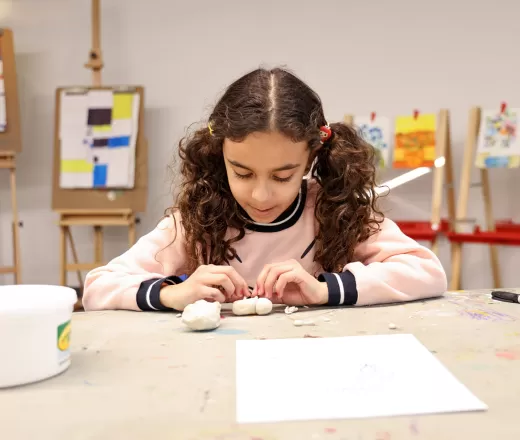 girl in art class molding clay