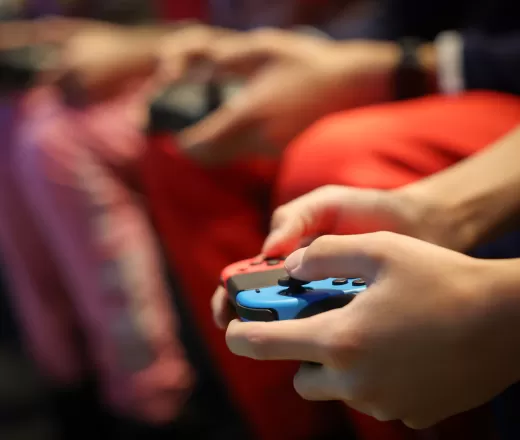 hands of youth holding video game controllers