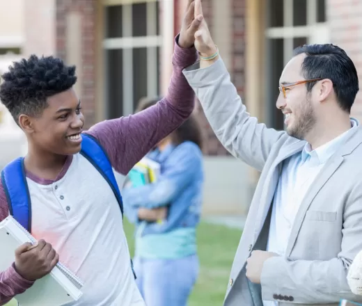 A youth and teacher high-five