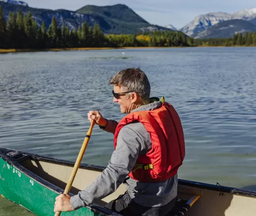 A man paddles in a canoe at Camp Chief Hector