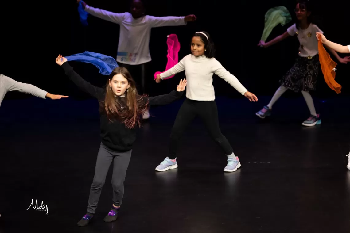 Young children dance on stage