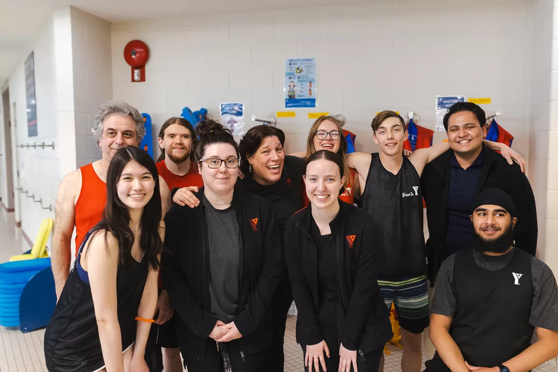 Group of men and women smiling and standing together