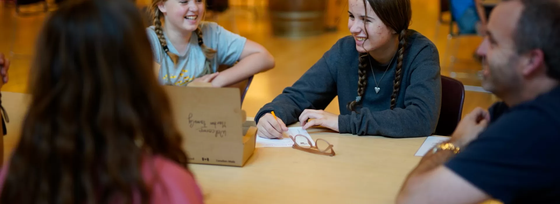 Girls smiling at a table in a cabin