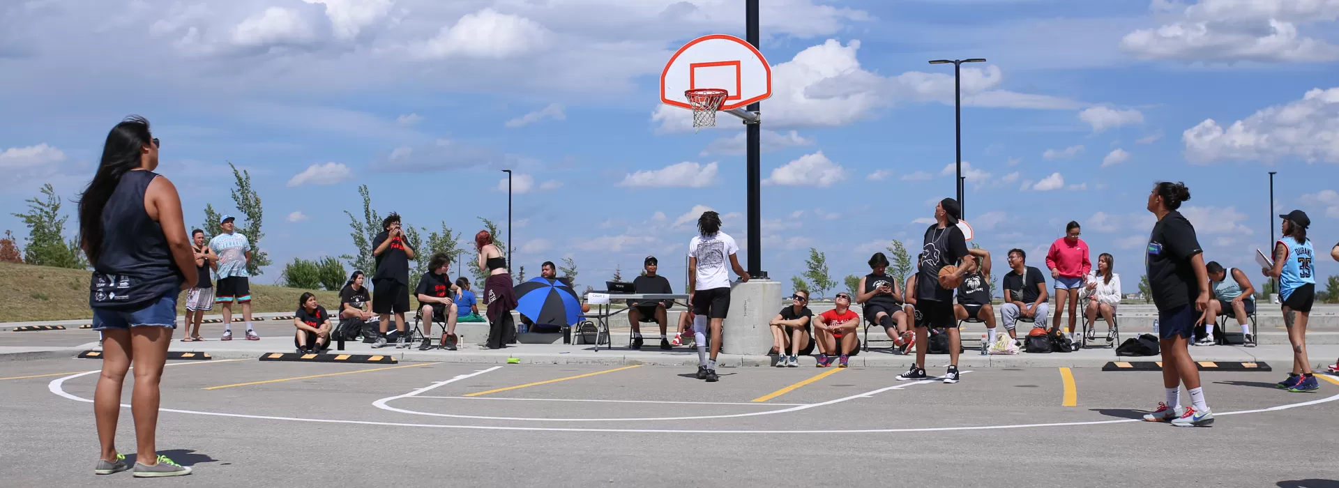 youth in white shirt throwing free throw shot in outside basketball court